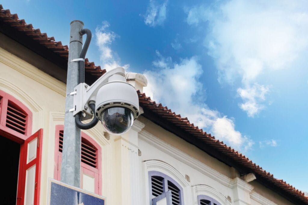 modern public cctv camera on ancient building wall with bright s