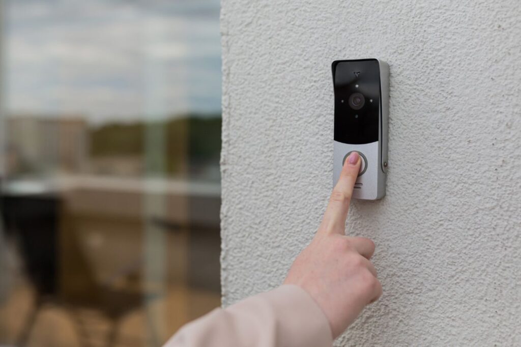 woman s hand uses doorbell wall house with surveillance camera